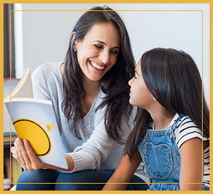 Smiling teacher reads to a student