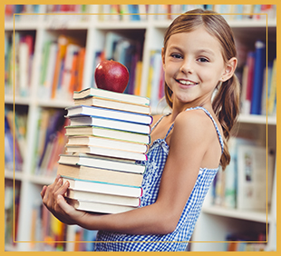 Smiling female student holds a stack of books with an apple on top